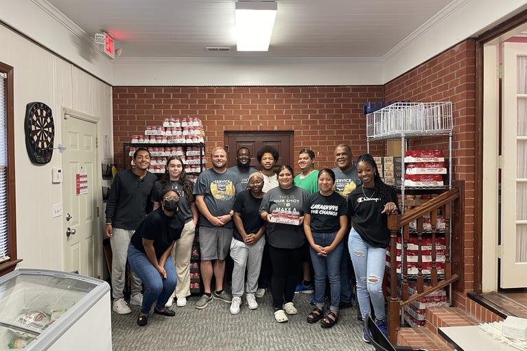Group standing in front of a large donation to the CARE Resource Center
