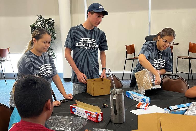 Group of three students working with kids